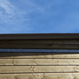 Drewniany wybieg dla psów z dachem z blachy falistej